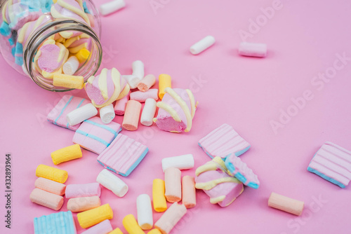 Colorful marshmallows in a glass on pink background. Party concept.