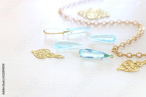 Delicate blue gemstones drops on white wooden background