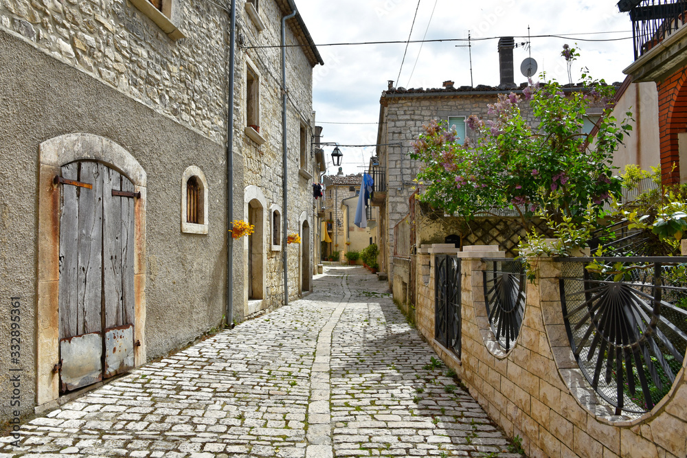 A narrow street between the old houses of the medieval village of Oratino, in Italy.