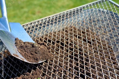 Compost sieve with a shovel and a wheelbarrow