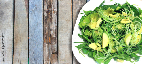 Raw vegan food. Salad of greens, fresh vegetables, avocado, cucumber, arugula, spinach, close-up