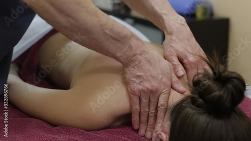 Doctor masseur making healing body spine massage to patient girl in clinic. Medical therapeutic massage. 