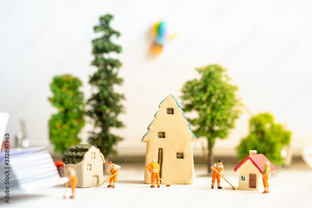 Miniature people worker cleaning home away to prevent COVID-19 coronavirus disease for infection risk using as background social distancing, disease prevention measures, shelter in place concept.