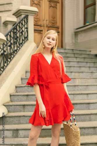 Street style fashion. Girl model in a multiply linen dresses. Spring Summer colors, Orange, blue, camel, black. Sight seen destination concept. Weekend shopping tour. Pretty girl tourist. 