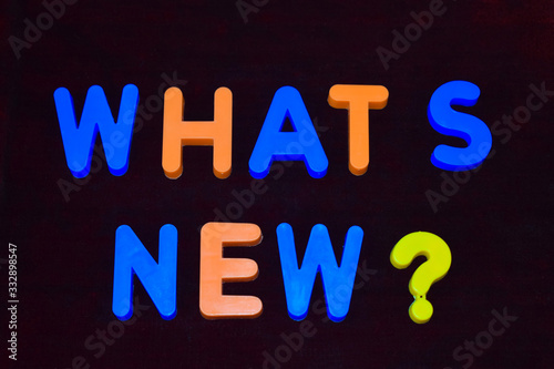 Whats new ? word written with different colored letter blocks on a dark background