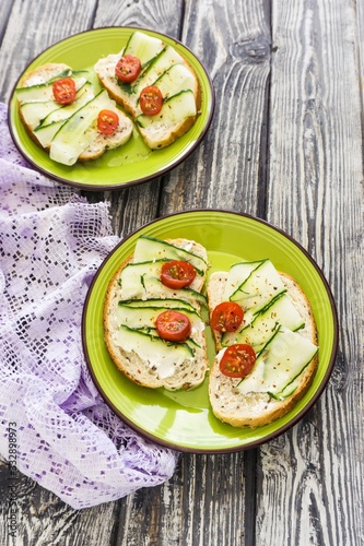 Healthy breakfast, toasts with cucumber and tomatoes sprinkled with dry herbs and spices, diet food, on a dark background, selective focus, close-up.
