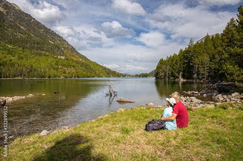 Beautiful Pyrenees mountain landscape, nice lake with tourist couple from Spain, Catalonia.