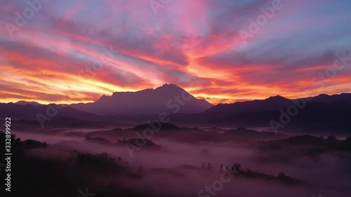 Amazing beautiful burning sky sunrise with Mount Kinabalu as background in rainforest jungle with foggy and cloud at Sabah, Borneo