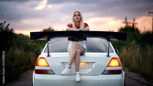 Girl sitting on a car photo