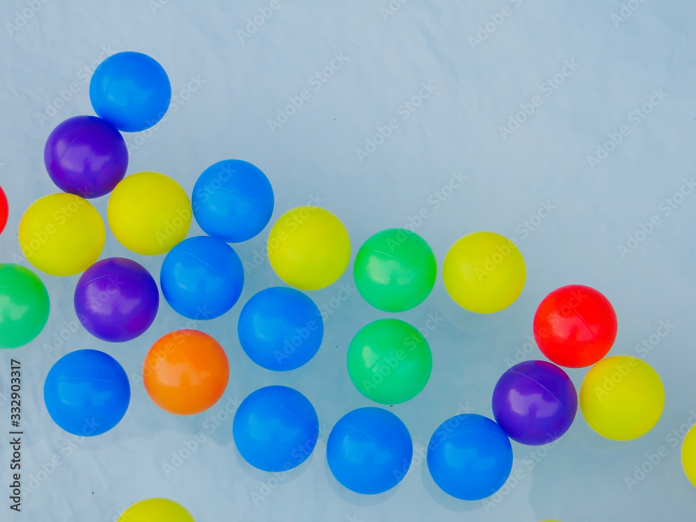 Many colored rubber balls float on the water.