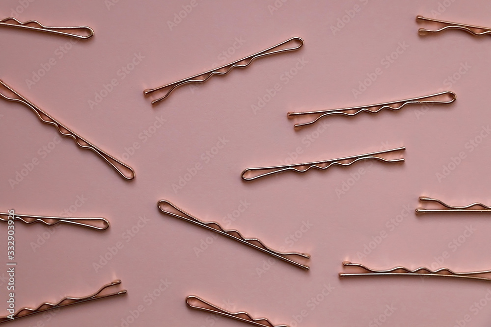 Golden hair clips on pastel pink background. Top view. Golden hair clips on pastel pink background. Top view.