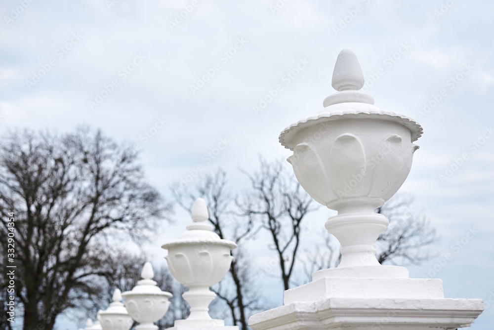 Naklejka premium White concrete fence with curved pillars in old historical park of ancient castle. Architectural background.