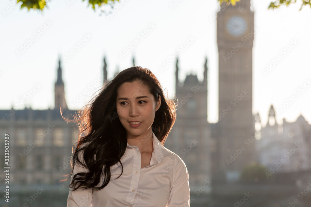 Fototapeta premium Asian business women near Big Ben, London, England. Girl in London during winter near Westminster bridge, London. oung female travel in London, England. Beautiful young Asian girl. 