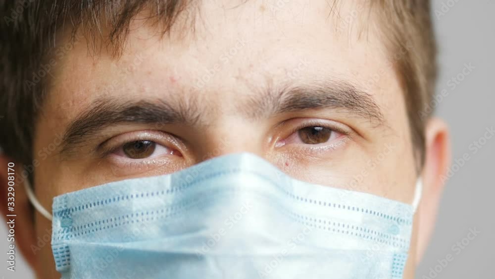 close up eyes of tired man in medical protective mask looking at camera, job of doctor, concept medicine and health close up eyes of tired man in medical protective mask looking at camera, job of doctor, concept medicine and health