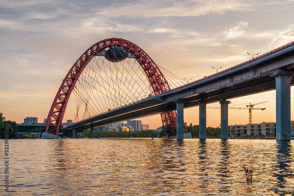 Sunset view of Picturesque bridge with big red arch over the Moscow river, Moscow, Russian Federation.