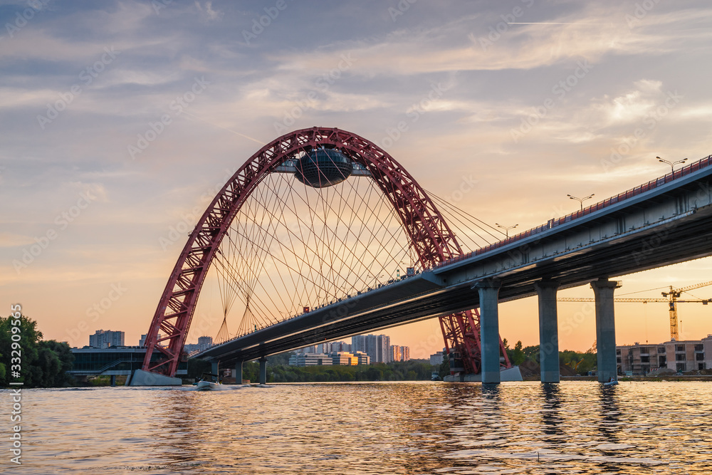 Sunset view of Picturesque bridge with big red arch over the Moscow river, Moscow, Russian Federation.