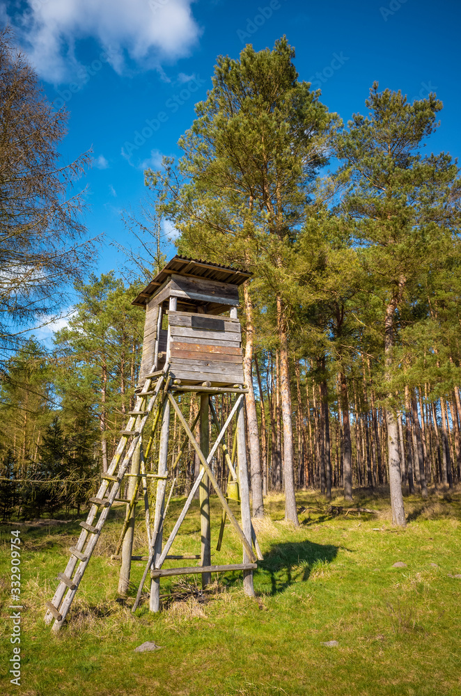 Wooden elevated deer hunting blind at the edge of a forest and field. Wooden elevated deer hunting blind at the edge of a forest and field.