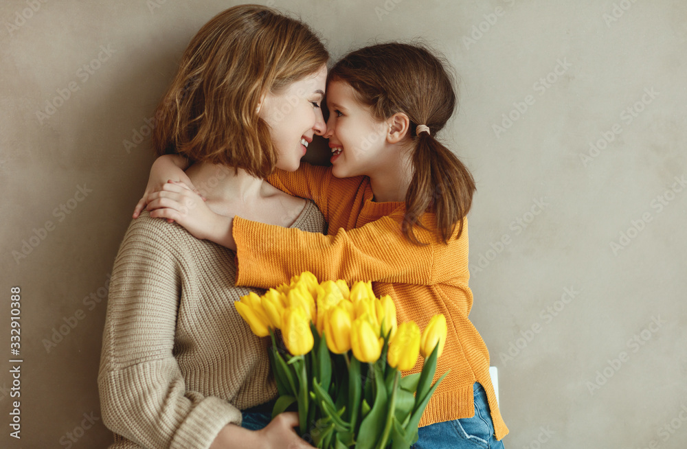 child daughter   gives mother   bouquet of flowers  yellow tulips. - obrazy, fototapety, plakaty 
