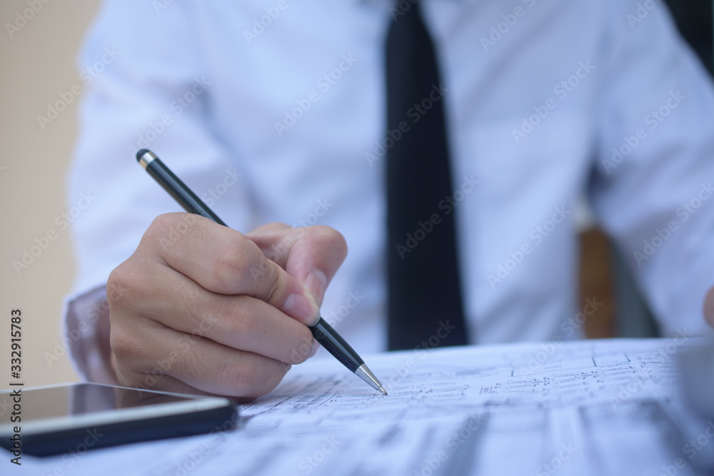 Businessman holding pen writing on paper document working,Close up hand write paperwork Businessman holding pen writing on paper document working,Close up hand write paperwork