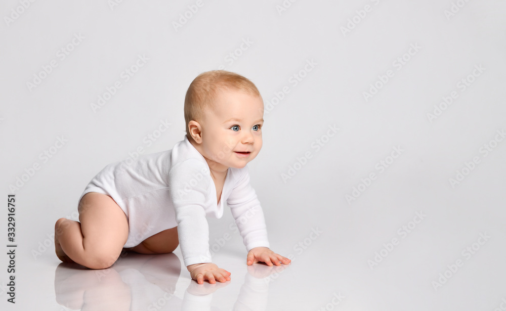 Chubby ginger baby boy in bodysuit, barefoot. He smiling, creeping on floor isolated on white background. Close up, copy space Chubby ginger baby boy in bodysuit, barefoot. He smiling, creeping on floor isolated on white background. Close up, copy space