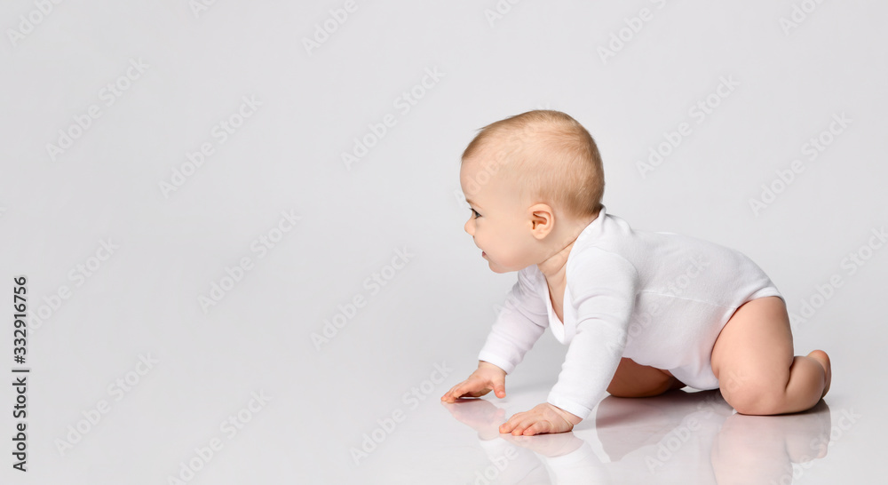 Chubby ginger baby boy in bodysuit, barefoot. He smiling, creeping on floor isolated on white background. Close up, copy space Chubby ginger baby boy in bodysuit, barefoot. He smiling, creeping on floor isolated on white background. Close up, copy space