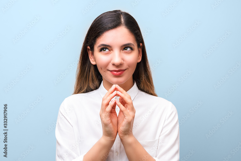 young sneaky woman thinking about something special or scheming something against blue background young sneaky woman thinking about something special or scheming something against blue background