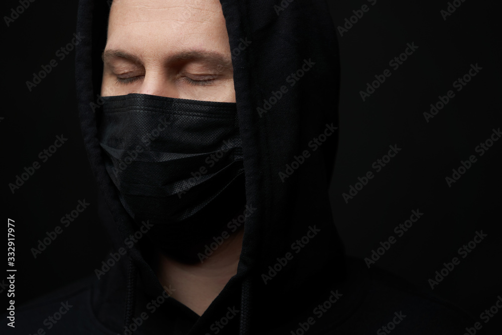 Young man wearing face mask over black background, close-up Young man wearing face mask over black background, close-up