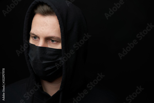 Young man wearing face mask over black background, close-up