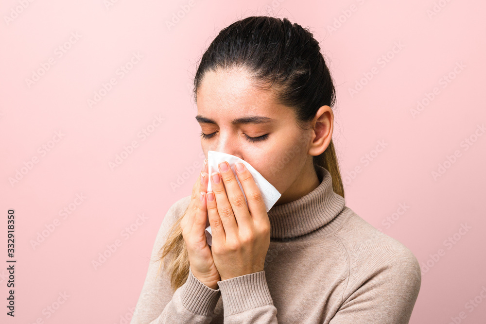 stop spreading coronavirus. young sick woman with fly or virus sneezing and coughing in a mask or napkin looking very hopeless stop spreading coronavirus. young sick woman with fly or virus sneezing and coughing in a mask or napkin looking very hopeless
