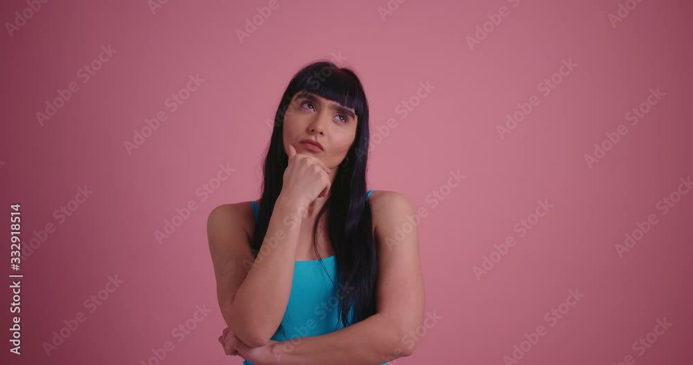 Amazing young thinking brunette woman in blue shirt have an idea on pink background Amazing young thinking brunette woman in blue shirt have an idea on pink background