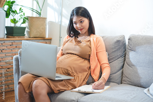 Vászonkép Pregnant Asian women are using the laptop to find information to prepare for motherhood