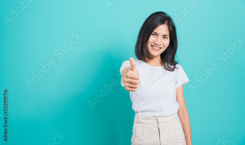Portrait Asian beautiful young woman standing, She made finger thumbs up