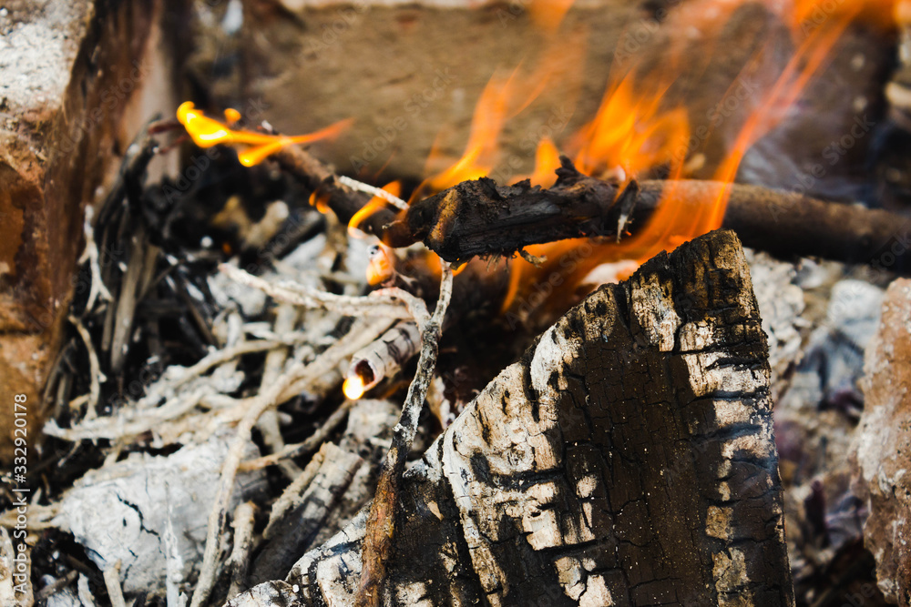 Burning wood (fire, coals and smoke). Lighting a fire from wooden logs and branches in a homemade barbecue made of bricks for cooking barbecue close up Burning wood (fire, coals and smoke). Lighting a fire from wooden logs and branches in a homemade barbecue made of bricks for cooking barbecue close up