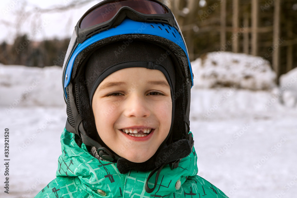 little boy on mountains in ski helmet with fallen first tooth little boy on mountains in ski helmet with fallen first tooth