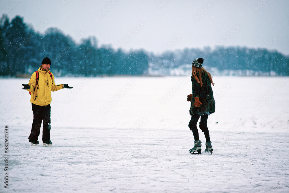 Young girl and man ice skating in snowy Trakai