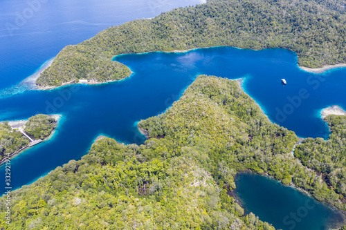 Beautiful coral reefs fringe the islands throughout Raja Ampat, Indonesia. This area is known for its incredibly high marine biodiversity and is a popular destination for water lovers.