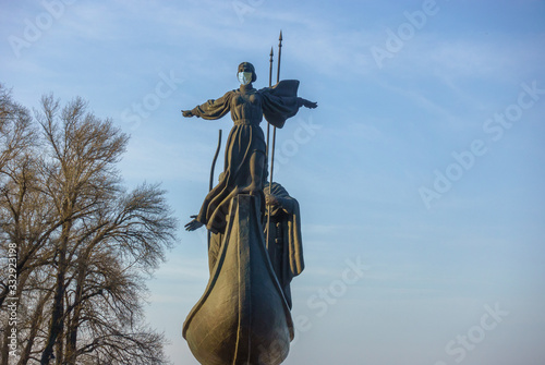 Kyiv Founders’ Monument. Girl Lybid in a medical mask. Allegory, post-processing photo