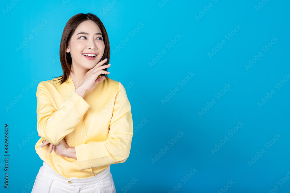 Beautiful young asian woman pretending to be happy with big smile happy beaming face in seamless blue isolated background. Presenter promotion, happy lifestyle, fresh pretty girl concept. Beautiful young asian woman pretending to be happy with big smile happy beaming face in seamless blue isolated background. Presenter promotion, happy lifestyle, fresh pretty girl concept.
