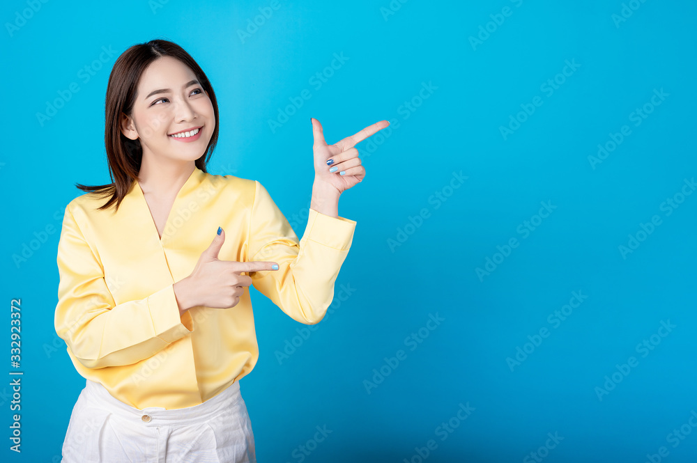 Beautiful young asian woman presenting point to copy space with big smile happy beaming face in seamless blue isolated background. Presenter promotion, happy lifestyle, fresh pretty girl concept. Beautiful young asian woman presenting point to copy space with big smile happy beaming face in seamless blue isolated background. Presenter promotion, happy lifestyle, fresh pretty girl concept.