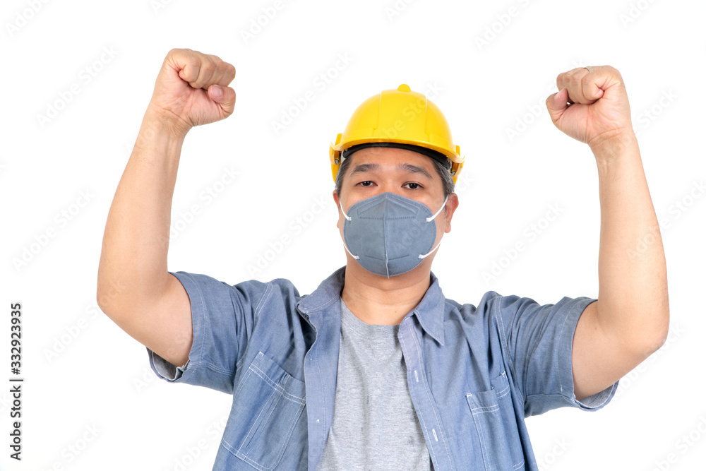 Male worker wearing a helmet and face mask and looking at camera in studio on isolated white background. Concept of protection from coronavirus (COVID-19).