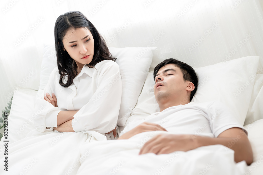 The asian wife have problems with snoring husband. Marriage and divorce issues. Stock Photo