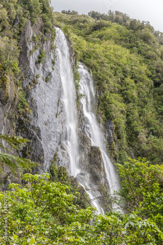 tall waterfall on steep slope with lush vegetation  near Whataroa  West Coast  New Zealand