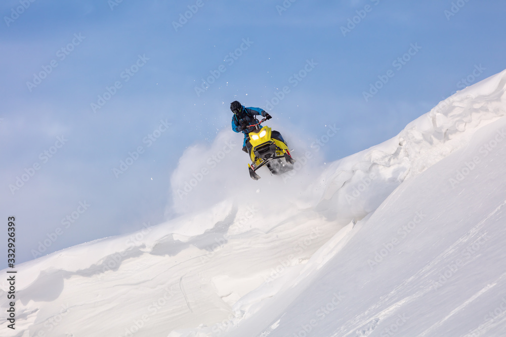 jump and ride in a big avalanche on a snowmobile with snow splashes and a storm. the snowmobiler is testing a new model of mountain snowmobile, the prototype of 2021. Winter FUN extreme
