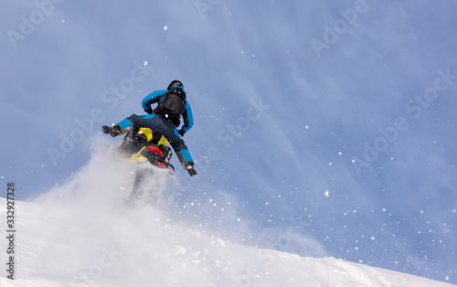 jump and ride in a big avalanche on a snowmobile with snow splashes and a storm. the snowmobiler is testing a new model of mountain snowmobile, the prototype of 2021. Winter FUN extreme