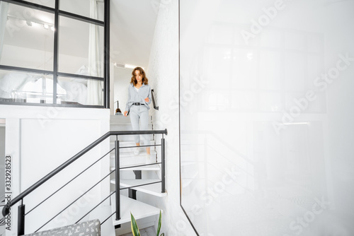 Interior view of the bright modern living room with a blurred in motion human figure walkiing the stairs