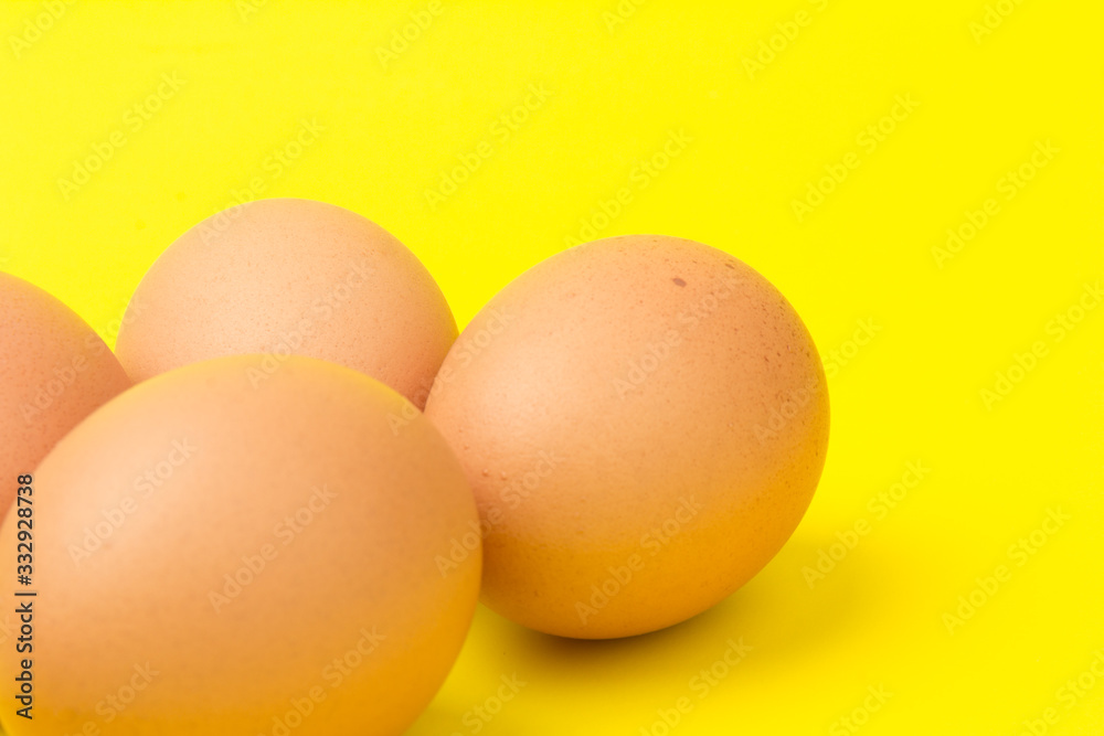 Brown eggs close up, isolated on yellow background. space for text Brown eggs close up, isolated on yellow background. space for text