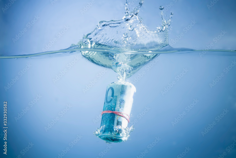 Euro bills sinking in water as a symbol of global economic crisis.