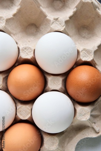 Brown and white chicken eggs in cardboard egg tray. Organic egg for healthy protein breakfast. Easter symbol. Raw chicken eggs. Vertical position 
