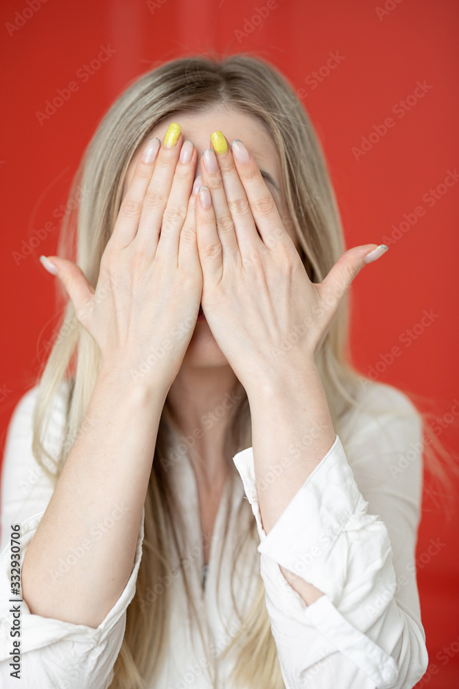 portrait of a very emotional girl with blond hair on a background of a red door portrait of a very emotional girl with blond hair on a background of a red door