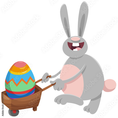 cartoon Easter bunny with big egg on wheelbarrow photo